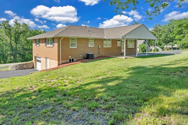 1104 Dolly Ann Dr, Covington, VA 24426 - back of property with central AC, an attached garage, asphalt driveway, a lawn, and brick siding