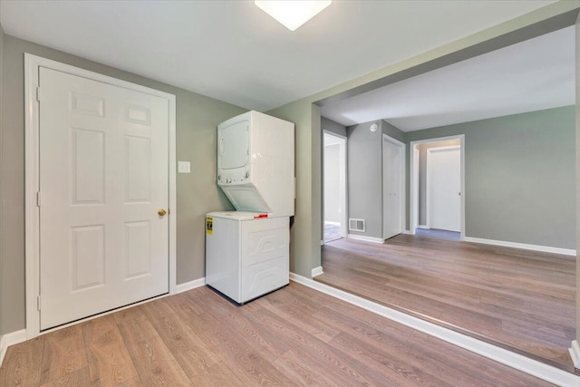 1104 Dolly Ann Dr, Covington, VA 24426 - laundry room with stacked washing machine and dryer, light wood-type flooring, and baseboards