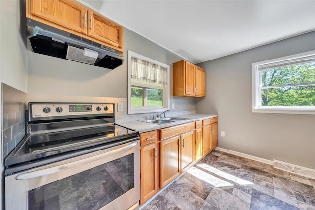 1104 Dolly Ann Dr, Covington, VA 24426 - kitchen featuring electric stove, under cabinet range hood, a sink, light countertops, and baseboards