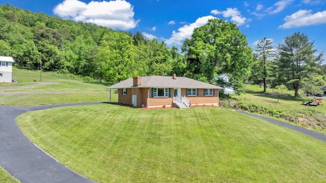 1104 Dolly Ann Dr, Covington, VA 24426 - view of front of house featuring a chimney, brick siding, a front lawn, and a wooded view