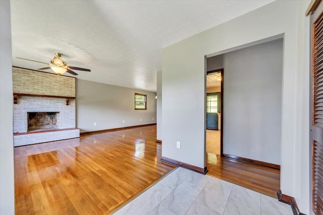 1104 Dolly Ann Dr, Covington, VA 24426 - unfurnished living room with ceiling fan, baseboards, a fireplace, and wood finished floors