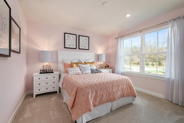 bedroom with baseboards and light colored carpet