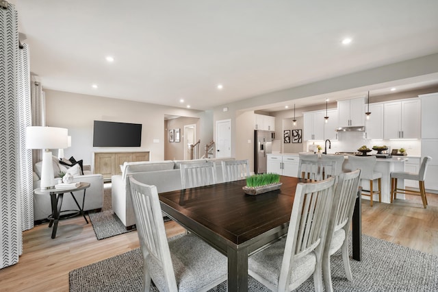 dining area with light wood-type flooring and recessed lighting