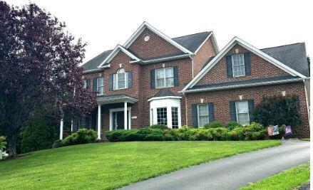 colonial home with a front lawn and brick siding