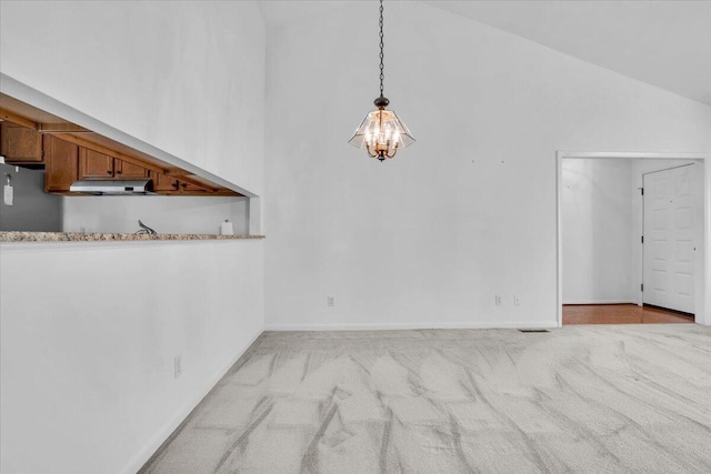unfurnished dining area with a chandelier, high vaulted ceiling, carpet flooring, and baseboards