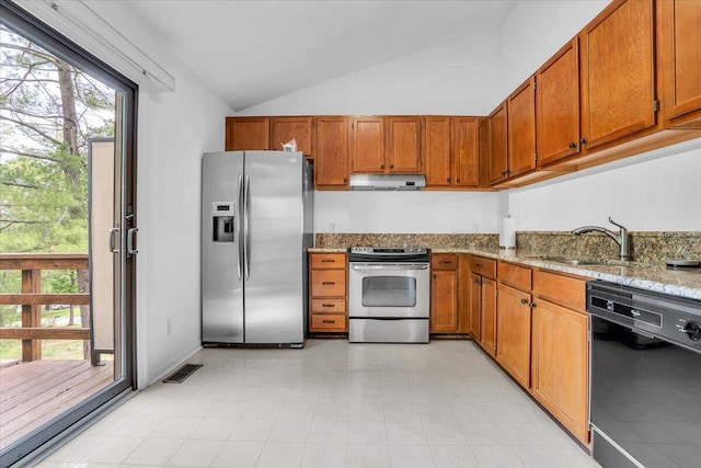 kitchen with stainless steel appliances, a sink, vaulted ceiling, exhaust hood, and brown cabinetry