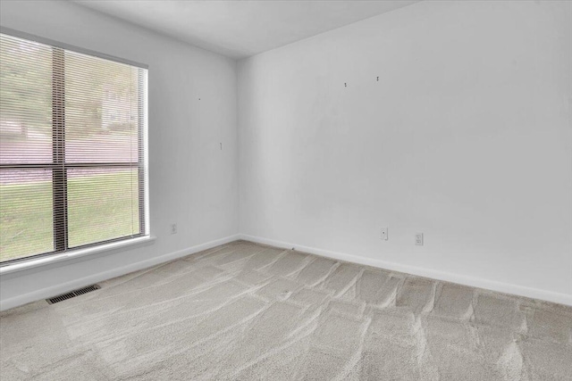 unfurnished room featuring carpet floors, baseboards, and plenty of natural light