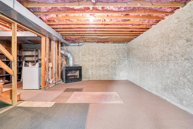 unfinished basement with washer / dryer and a wood stove