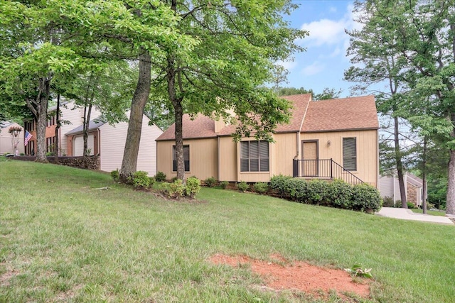 view of front of home featuring roof with shingles and a front lawn