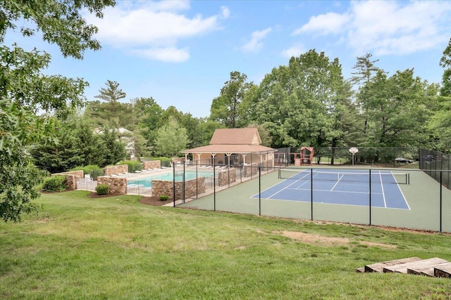 view of tennis court with a community pool