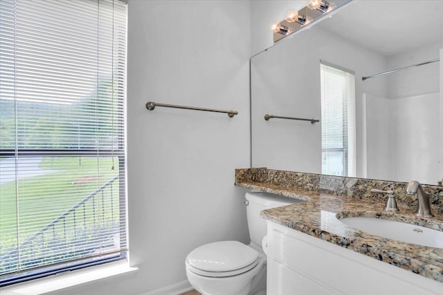 full bath with toilet, vanity, and baseboards