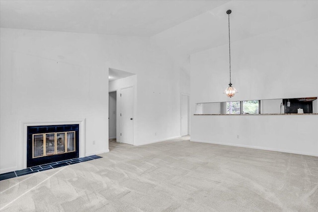 unfurnished living room featuring high vaulted ceiling, carpet flooring, a fireplace with flush hearth, baseboards, and a chandelier