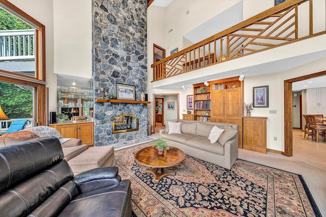 217 Anthony Home Rd, Huddleston, VA 24104 - living area featuring a towering ceiling, healthy amount of natural light, baseboards, a stone fireplace, and light carpet