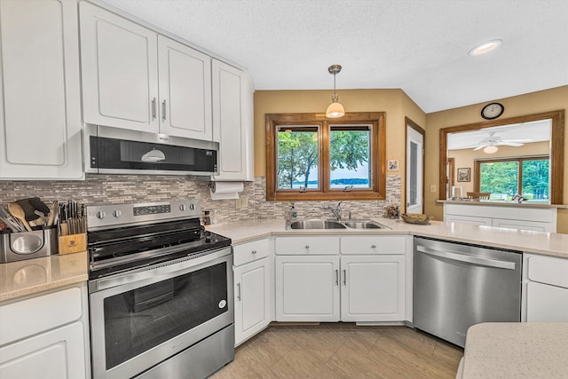 217 Anthony Home Rd, Huddleston, VA 24104 - kitchen with stainless steel appliances, a sink, healthy amount of natural light, decorative backsplash, and a textured ceiling