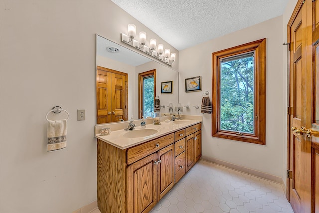 217 Anthony Home Rd, Huddleston, VA 24104 - bathroom featuring double vanity, tile patterned flooring, baseboards, and a textured ceiling