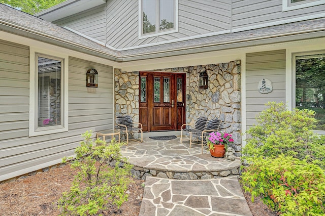217 Anthony Home Rd, Huddleston, VA 24104 - view of exterior entry with a porch, stone siding, and roof with shingles