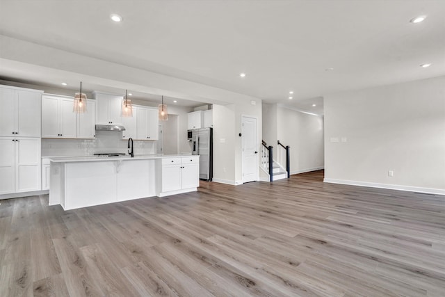 7036 Fairway Ridge Rd, Salem, VA 24153 - kitchen with appliances with stainless steel finishes, open floor plan, under cabinet range hood, recessed lighting, and light wood finished floors