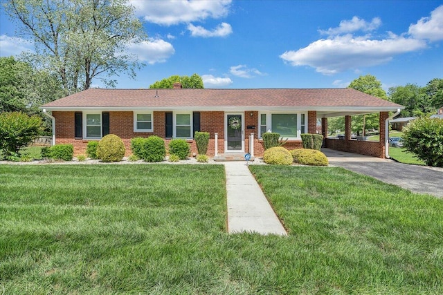 ranch-style house with driveway, a carport, brick siding, a chimney, and a front yard