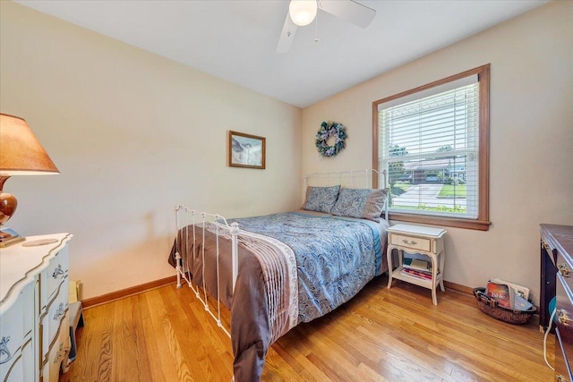 bedroom featuring light wood-type flooring, baseboards, and ceiling fan