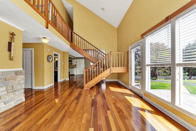 145 W Arrowhead Ct, Troutville, VA 24175 - unfurnished living room with plenty of natural light, wood finished floors, stairs, baseboards, and high vaulted ceiling