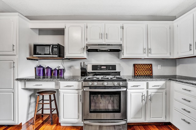 145 W Arrowhead Ct, Troutville, VA 24175 - kitchen featuring stainless steel range with gas cooktop, under cabinet range hood, wood finished floors, white cabinetry, and a textured ceiling