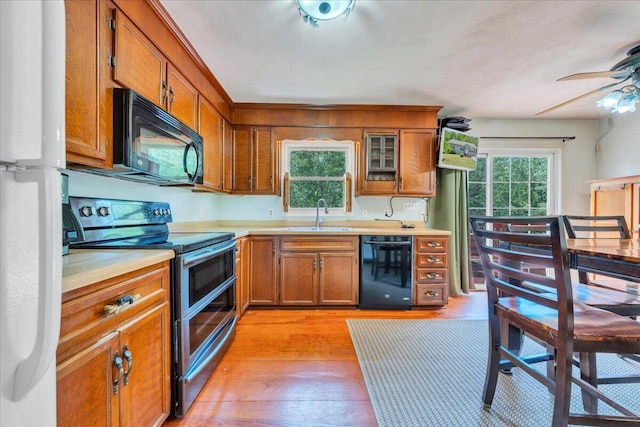 1793 Sandy Level Rd, Goodview, VA 24095 - kitchen featuring black appliances, a sink, brown cabinetry, light countertops, and light wood-type flooring