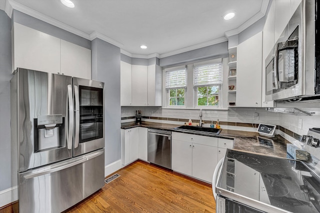 2102 Berkley Ave SW, Roanoke, VA 24015 - kitchen featuring appliances with stainless steel finishes, a sink, crown molding, dark countertops, and white cabinets