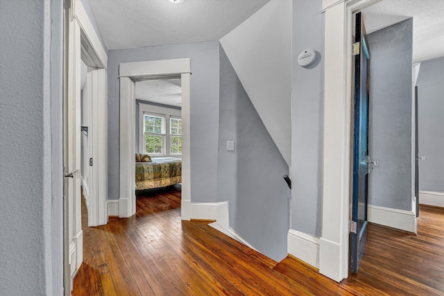 2102 Berkley Ave SW, Roanoke, VA 24015 - hall with wood-type flooring, baseboards, a textured ceiling, and an upstairs landing