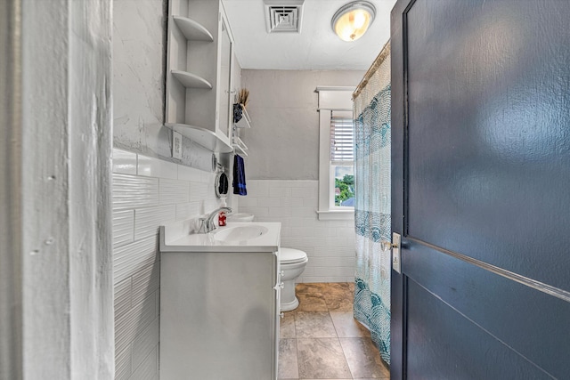 2102 Berkley Ave SW, Roanoke, VA 24015 - bathroom with toilet, vanity, and tile walls