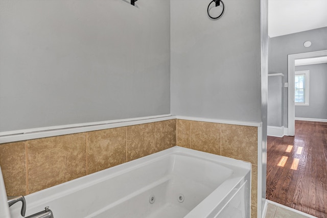 1228 Thomas Ave NW, Roanoke, VA 24017 - bathroom featuring a jetted tub, baseboards, and wood finished floors