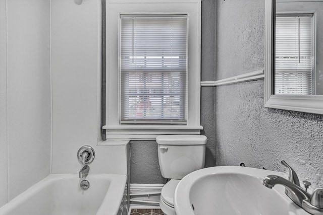 1228 Thomas Ave NW, Roanoke, VA 24017 - full bathroom featuring a tub, toilet, a textured wall, and a sink