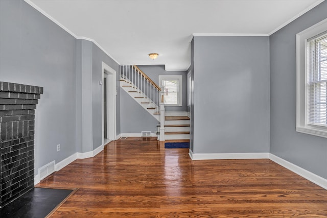 1228 Thomas Ave NW, Roanoke, VA 24017 - unfurnished living room featuring stairway, wood finished floors, crown molding, a brick fireplace, and baseboards