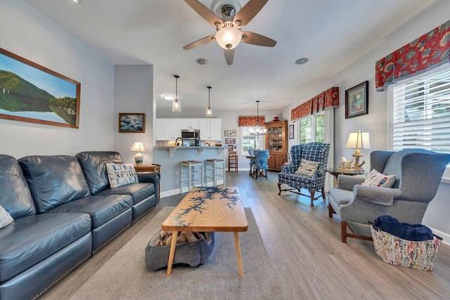 1017 Joffrey Dr, Huddleston, VA 24104 - living room featuring wood finished floors, a ceiling fan, a chandelier, and baseboards