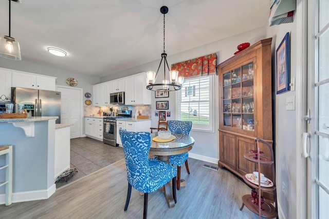 1017 Joffrey Dr, Huddleston, VA 24104 - dining room featuring a chandelier, baseboards, and wood finished floors