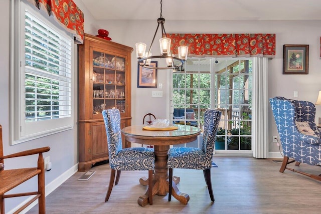 1017 Joffrey Dr, Huddleston, VA 24104 - dining space featuring a chandelier, wood finished floors, healthy amount of natural light, and baseboards