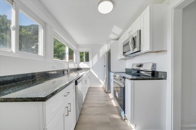 1008 Primrose St SE, Roanoke, VA 24014 - kitchen featuring stainless steel appliances, light wood finished floors, white cabinetry, and dark stone counters