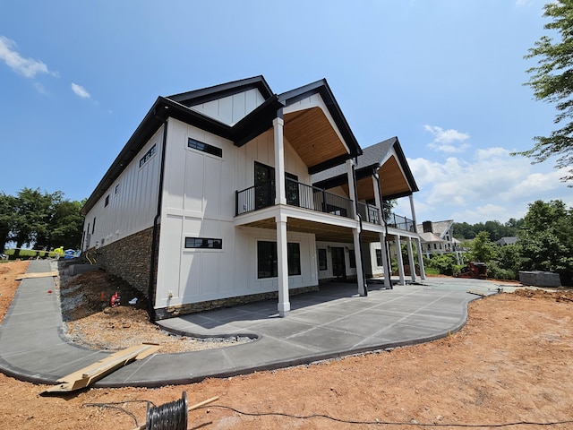 95 Shoreline Cir, Penhook, VA 24137 - rear view of property featuring board and batten siding, a balcony, and a patio