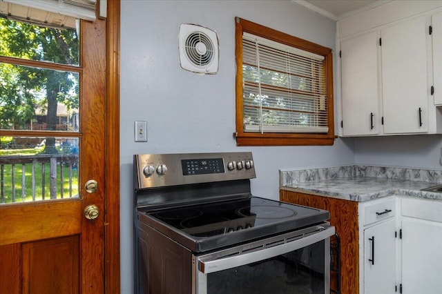 1829 Court St NW, Roanoke, VA 24012 - kitchen with stainless steel range with electric stovetop, crown molding, light countertops, and white cabinetry