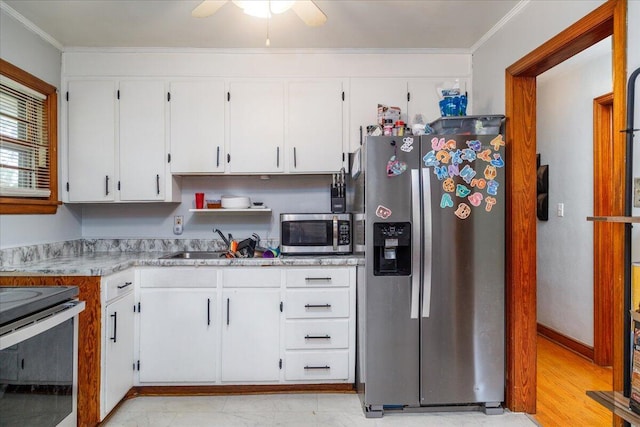 1829 Court St NW, Roanoke, VA 24012 - kitchen featuring appliances with stainless steel finishes, white cabinetry, ornamental molding, light countertops, and a sink