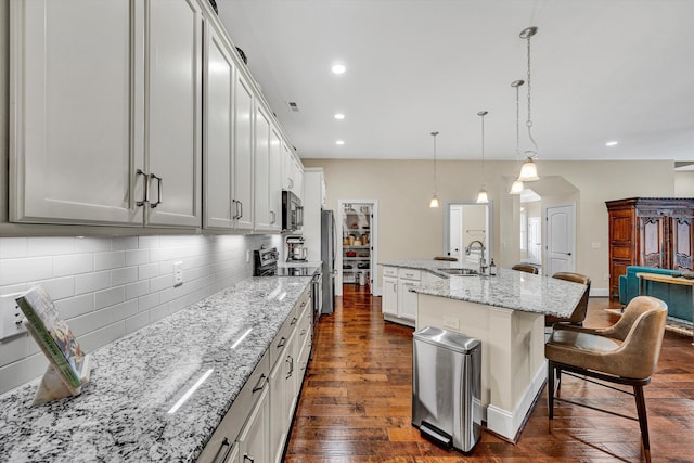 4742 Leigh Ln, Roanoke, VA 24018 - kitchen with a sink, dark wood finished floors, a breakfast bar area, tasteful backsplash, and stainless steel appliances