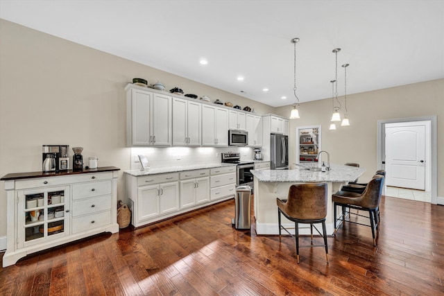 4742 Leigh Ln, Roanoke, VA 24018 - kitchen with stainless steel appliances, a sink, an island with sink, a breakfast bar, and dark wood finished floors