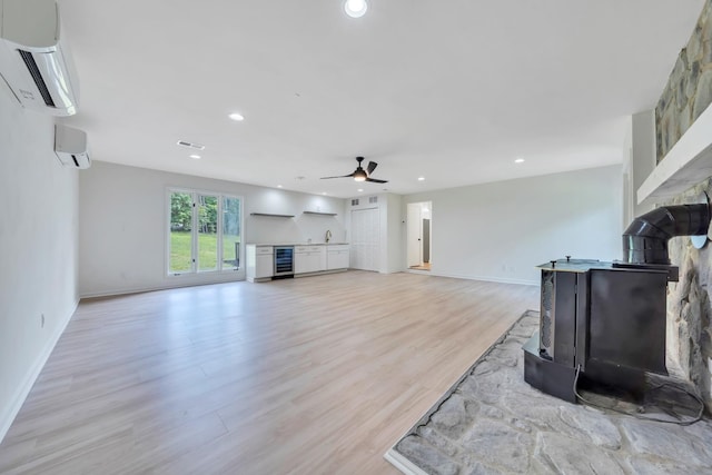 6695 Raintree Rd, Roanoke, VA 24018 - unfurnished living room with an AC wall unit, a wood stove, wine cooler, ceiling fan, and recessed lighting