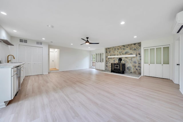 6695 Raintree Rd, Roanoke, VA 24018 - unfurnished living room featuring a ceiling fan, recessed lighting, light wood-style flooring, a wall mounted air conditioner, and baseboards