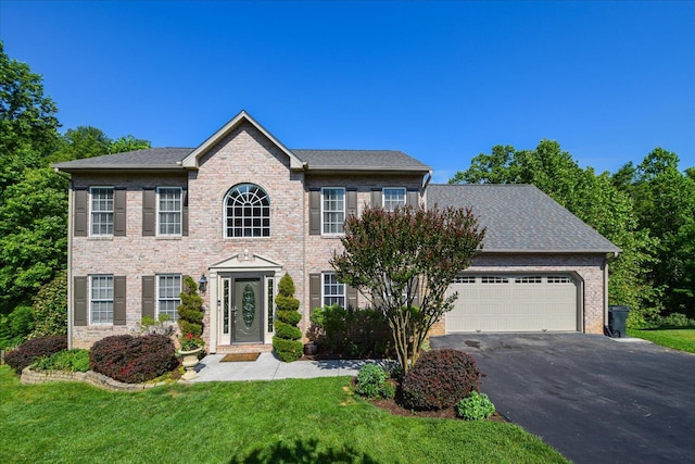 7635 Peebles Ln, Roanoke, VA 24018 - colonial house with driveway, an attached garage, a front yard, and brick siding