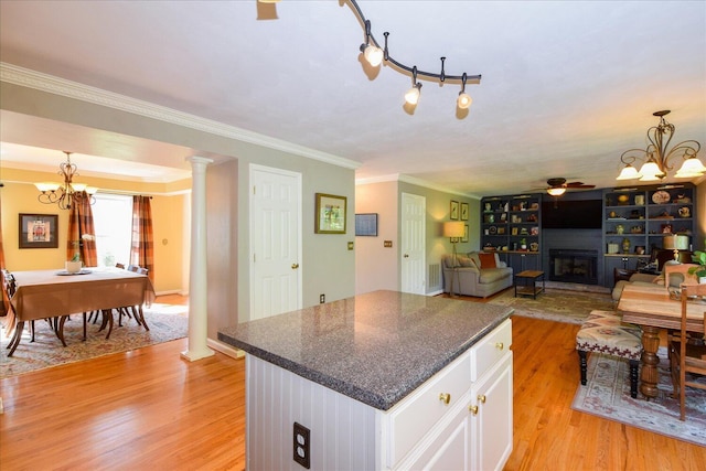 7635 Peebles Ln, Roanoke, VA 24018 - kitchen featuring a chandelier, light wood-type flooring, white cabinets, a fireplace with raised hearth, and ornamental molding