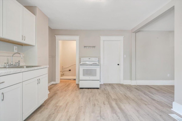 1120 6th St SE, Roanoke, VA 24013 - kitchen featuring white electric stove, a sink, light wood-style flooring, white cabinets, and baseboards