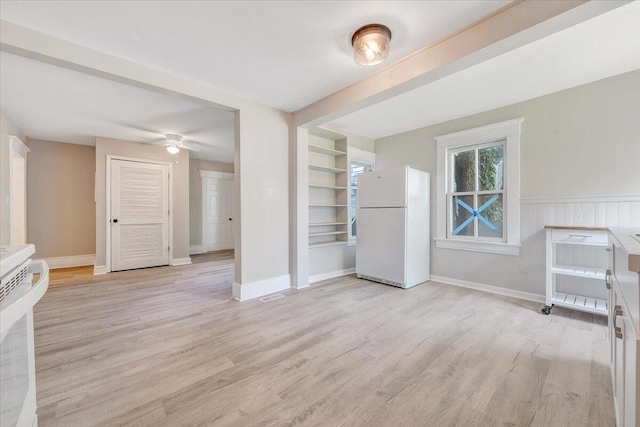 1120 6th St SE, Roanoke, VA 24013 - unfurnished living room with light wood finished floors, a ceiling fan, and baseboards