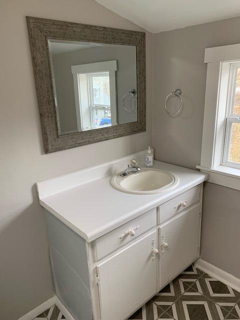 1120 6th St SE, Roanoke, VA 24013 - bathroom with vanity, baseboards, and vaulted ceiling