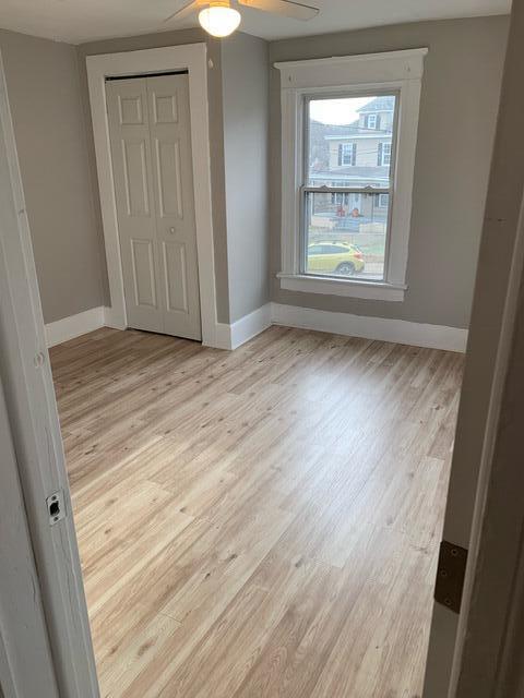 1120 6th St SE, Roanoke, VA 24013 - unfurnished bedroom with baseboards, light wood finished floors, a closet, and ceiling fan