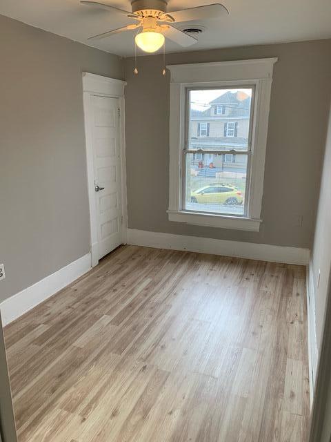 1120 6th St SE, Roanoke, VA 24013 - spare room with baseboards, light wood finished floors, and a ceiling fan